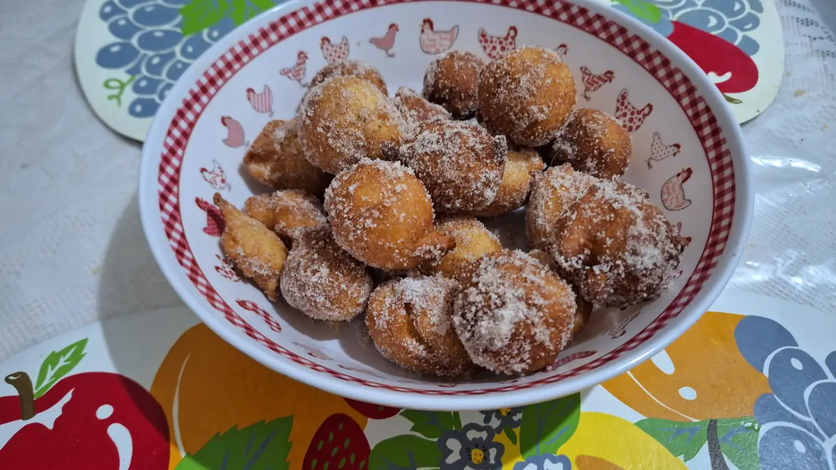 Tigela com bolinhos de chuva passados no açúcar e canela